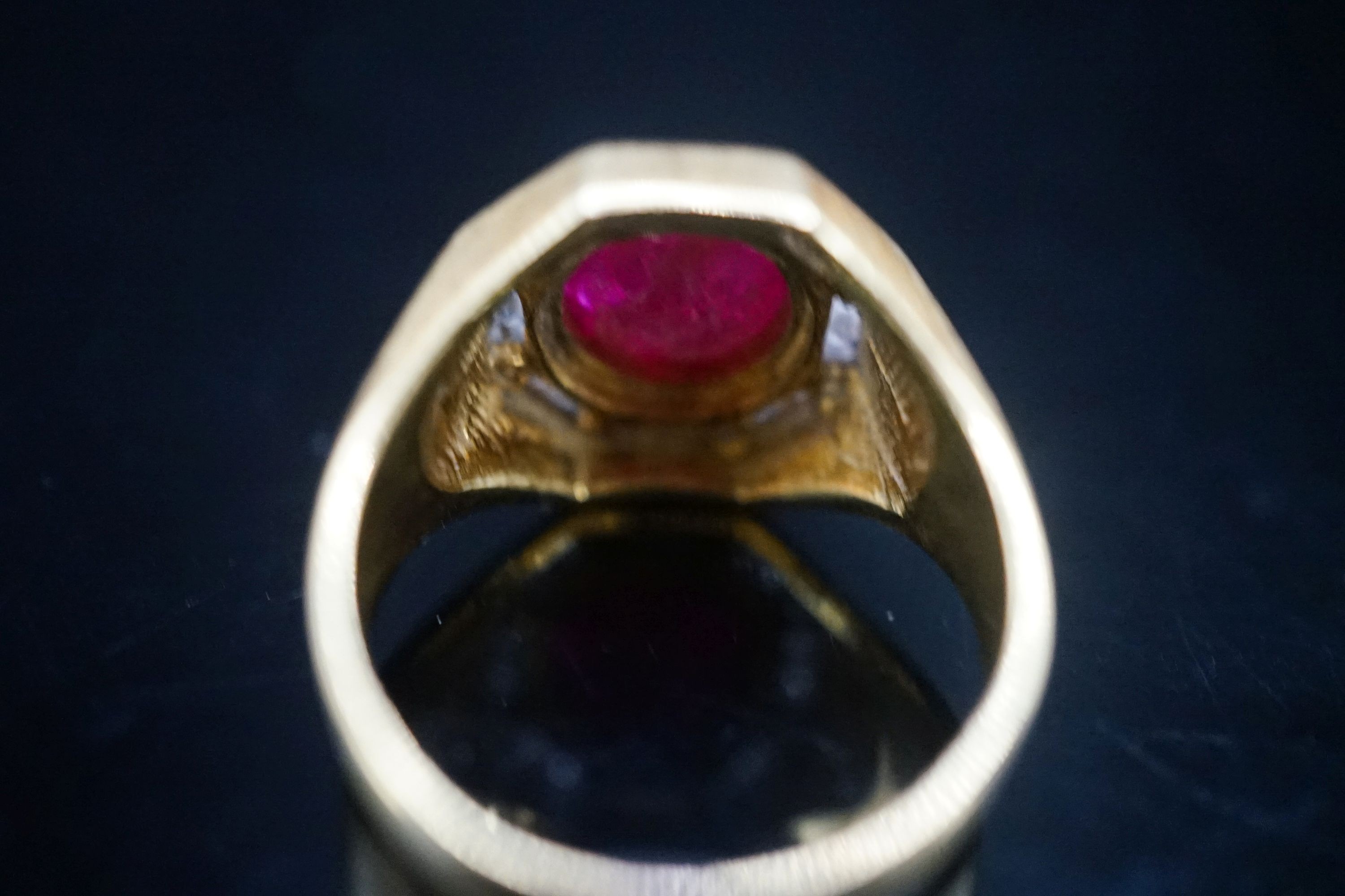 A modern continental yellow metal, cabochon ruby and diamond cluster set octagonal dress ring, size Q, gross weight 9.9 grams.